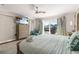 Bright main bedroom featuring a ceiling fan, TV, dresser, and sliding glass doors leading to a scenic view at 3691 Center Cir, Largo, FL 33774