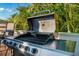 Stainless steel outdoor grill ready for a summer party, surrounded by tropical landscaping on a sunny day at 3691 Center Cir, Largo, FL 33774