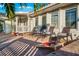 This outdoor brick patio features lounge chairs and a cornhole game, perfect for relaxing in the sun at 3691 Center Cir, Largo, FL 33774