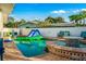 This backyard pool features an inflatable alligator and water slide, plus a brick patio with furniture and decorations at 3691 Center Cir, Largo, FL 33774