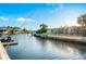 Picturesque waterfront view with a boat docked at a private pier, lush landscaping, and beautiful homes at 3691 Center Cir, Largo, FL 33774