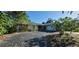 Charming home with mature landscaping, a driveway, and a welcoming red front door at 3717 Mckay Creek Dr, Largo, FL 33770