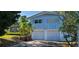 Two-story home featuring blue siding, white garage doors, and steps leading to the front entrance at 3717 Mckay Creek Dr, Largo, FL 33770
