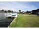 Backyard showcasing lush green grass, a private dock, and serene waterfront views at 3839 Star Island Dr, Holiday, FL 34691