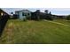 Large backyard with lush lawn, enclosed lanai, and secure fencing creating an inviting outdoor space at 3839 Star Island Dr, Holiday, FL 34691