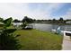 Beautiful waterfront backyard with lush green grass and a charming dock on a sunny day at 3839 Star Island Dr, Holiday, FL 34691