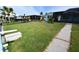 Spacious backyard featuring a home, screened patio, and well-maintained lawn at 3839 Star Island Dr, Holiday, FL 34691