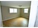 Bedroom featuring hardwood floors, white trim, and two windows for natural light at 3839 Star Island Dr, Holiday, FL 34691