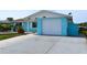 Side view of the quaint home featuring an attached garage and extended driveway at 3839 Star Island Dr, Holiday, FL 34691