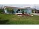 Landscaped front yard with a blue painted home and attached one car garage at 3839 Star Island Dr, Holiday, FL 34691