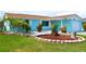 Landscaped front yard featuring lush green lawn and stone-bordered flower beds accentuating this quaint home at 3839 Star Island Dr, Holiday, FL 34691