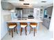 Bright kitchen with a large island, breakfast bar, updated lighting, and stainless steel appliances at 3839 Star Island Dr, Holiday, FL 34691