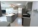 Open kitchen with gray cabinets, island with seating, and stainless steel appliances at 3839 Star Island Dr, Holiday, FL 34691
