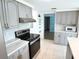 Modern kitchen with gray cabinets, white countertops and stainless steel appliances at 3839 Star Island Dr, Holiday, FL 34691