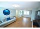 Open-concept living area with wood floors, ocean-themed decorations, a large window, and a view to other spaces at 3839 Star Island Dr, Holiday, FL 34691