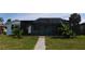 Exterior view of a home with a large screened patio, perfect for enjoying the outdoors at 3839 Star Island Dr, Holiday, FL 34691