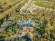 Aerial view of a resort-style pool and clubhouse surrounded by lush greenery and tennis courts at 3922 Silverlake Way, Wesley Chapel, FL 33544