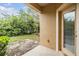 Cozy back porch with door and a view of the home's yard and greenery at 3922 Silverlake Way, Wesley Chapel, FL 33544