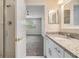 Bathroom with glass enclosed shower and vanity with granite countertops, view into the bedroom area at 3922 Silverlake Way, Wesley Chapel, FL 33544