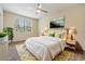 Bright bedroom with large window, ceiling fan, and a comfortable bed with stylish linens and modern decor at 3922 Silverlake Way, Wesley Chapel, FL 33544