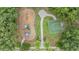 Aerial view of a community playground with slides, swings, and a basketball court surrounded by lush trees at 3922 Silverlake Way, Wesley Chapel, FL 33544
