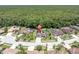 An aerial view of a well-maintained home located on a picturesque lot surrounded by lush greenery at 4049 Wellington Pkwy, Palm Harbor, FL 34685