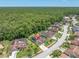 This aerial view showcases the home's tile roof and proximity to lush green surroundings and nearby neighborhood at 4049 Wellington Pkwy, Palm Harbor, FL 34685