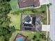 Aerial view of a private backyard oasis with a screened pool, solar panels, and lush landscaping at 4049 Wellington Pkwy, Palm Harbor, FL 34685