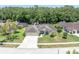 Aerial view of a home with three-car garage surrounded by lush greenery in a quiet neighborhood at 4049 Wellington Pkwy, Palm Harbor, FL 34685
