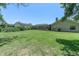 Lush backyard with a sprawling green lawn and mature trees, offering a serene setting at 4049 Wellington Pkwy, Palm Harbor, FL 34685