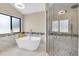 Luxurious bathroom with a freestanding tub, large window, and glass-enclosed shower at 4049 Wellington Pkwy, Palm Harbor, FL 34685