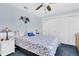 Comfortable bedroom with blue walls, floral bedspread, ceiling fan, and double closets at 4049 Wellington Pkwy, Palm Harbor, FL 34685