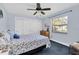 Bright bedroom with a floral bedspread, ceiling fan, and a sunlit window with neighborhood views at 4049 Wellington Pkwy, Palm Harbor, FL 34685