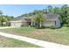 Charming home boasts a well-manicured lawn and an attached three-car garage at 4049 Wellington Pkwy, Palm Harbor, FL 34685
