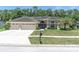 Charming home with a spacious three-car garage, manicured lawn, and elegant double-door entry at 4049 Wellington Pkwy, Palm Harbor, FL 34685