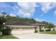 Beautiful house has a three-car garage and a well-manicured lawn at 4049 Wellington Pkwy, Palm Harbor, FL 34685