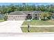 Charming home featuring a three-car garage, tile roof, lush lawn, and meticulously manicured landscaping at 4049 Wellington Pkwy, Palm Harbor, FL 34685