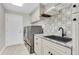 Well-organized laundry room featuring a modern washer/dryer, countertop, and patterned wallpaper at 4049 Wellington Pkwy, Palm Harbor, FL 34685
