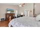 Cozy main bedroom with wood floors, ceiling fan and a view into the attached bathroom at 4049 Wellington Pkwy, Palm Harbor, FL 34685