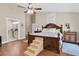 Spacious main bedroom featuring a wooden bed, ceiling fan, and doorway to the primary bathroom at 4049 Wellington Pkwy, Palm Harbor, FL 34685