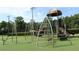 Community playground with swings, slide, climbing bars, basketball court and manicured turf at 4049 Wellington Pkwy, Palm Harbor, FL 34685