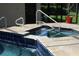 Inviting pool-side jacuzzi with tiled accents, easy access steps, and a lush landscaped setting at 4049 Wellington Pkwy, Palm Harbor, FL 34685