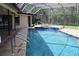 Beautiful pool and jacuzzi with a screen enclosure, seamlessly connected to the home's exterior at 4049 Wellington Pkwy, Palm Harbor, FL 34685