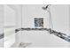 Modern shower with white subway tile, decorative accent stripe, niche, and granite bench at 4049 Wellington Pkwy, Palm Harbor, FL 34685