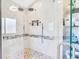 Modern shower with dual showerheads and a glass enclosure, tiled with neutral colors at 4049 Wellington Pkwy, Palm Harbor, FL 34685