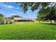 Expansive grassy backyard provides a relaxing view of the home, pool, and mature trees at 414 Summit Chase Dr, Valrico, FL 33594