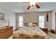Bedroom featuring two windows, ceiling fan, side table, lamp, and wooden dresser at 414 Summit Chase Dr, Valrico, FL 33594