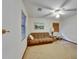 This carpeted room features a fan, a painting and a comfortable couch under a window at 414 Summit Chase Dr, Valrico, FL 33594