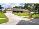 Charming brick home with a well-manicured front lawn, mature landscaping, and a two-car garage at 414 Summit Chase Dr, Valrico, FL 33594