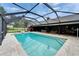 Relax in the screened-in pool with a diving board with a view of the home's outdoor living space at 414 Summit Chase Dr, Valrico, FL 33594